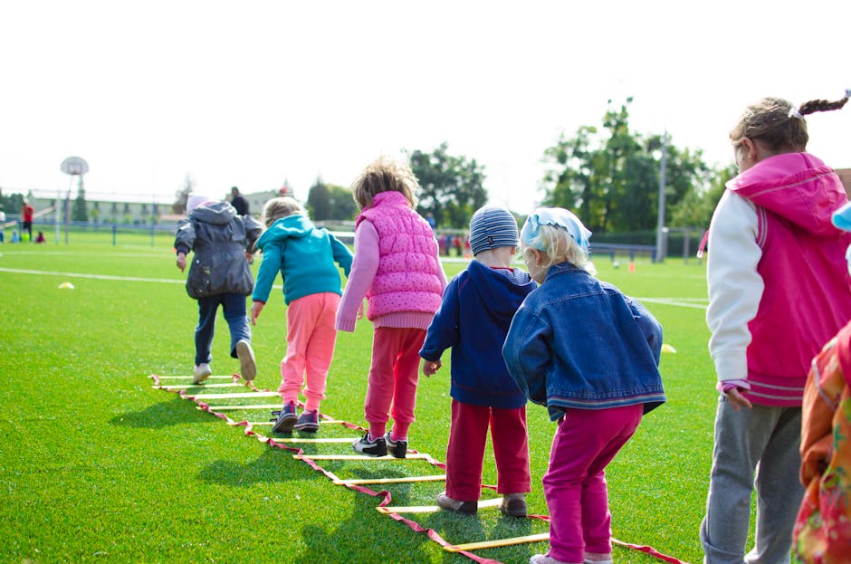 Bambini in fila che giocano su un prato verde, simbolo del calo demografico e della crisi educativa in Italia