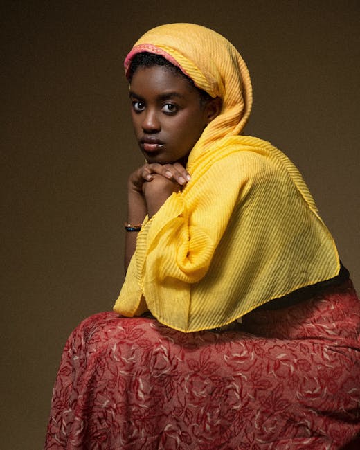 Giovane donna con hijab giallo e gonna rossa, simbolo di consapevolezza e interpretazione critica dei media digitali