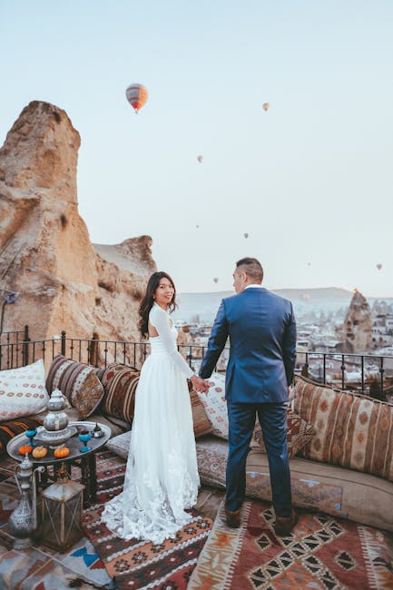 Coppia mano nella mano a Macondo con mongolfiere sullo sfondo, un viaggio nel realismo magico e nell'amore eterno.