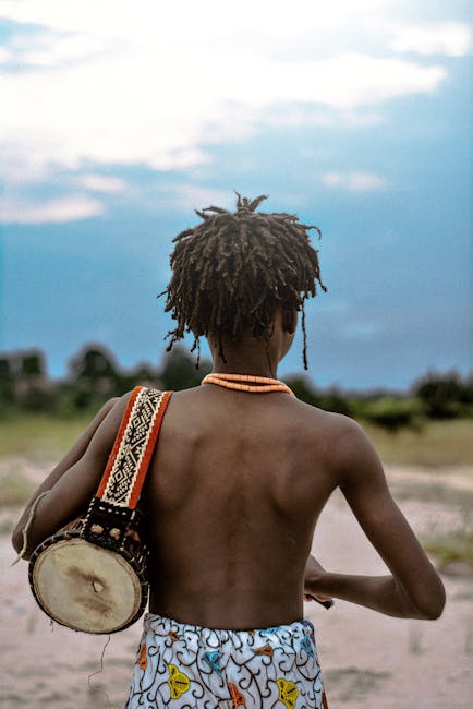 Giovane con tamburo tradizionale africano, strumento musicale unico e culturale, viaggio nelle sfumature sonore