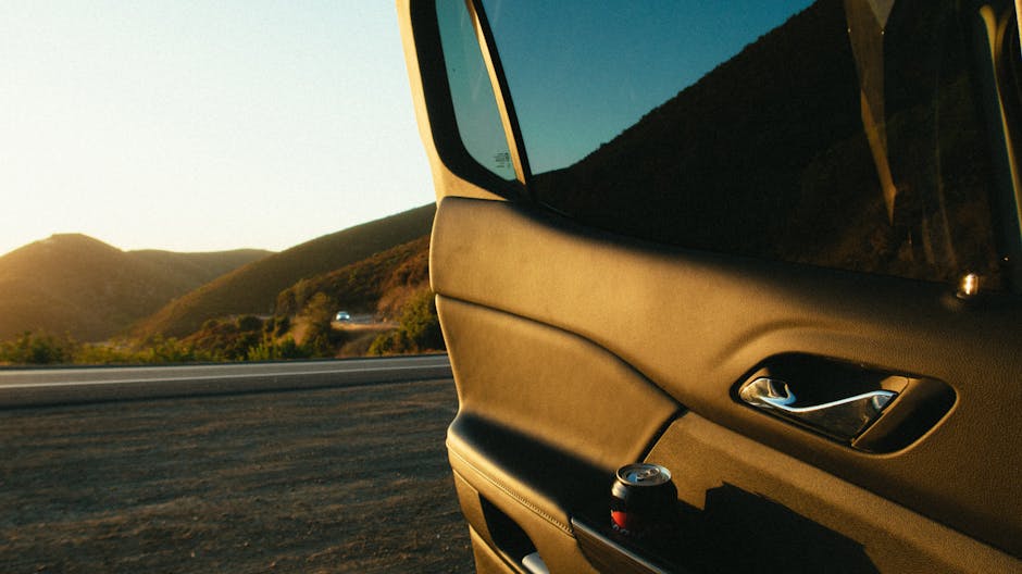 Portiera auto aperta con lattina e vista panoramica, metafora del percorso formativo per il Concorso Scuola 2025 e i requisiti di servizio.