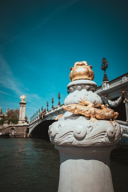 Dettaglio del Ponte Alessandro III a Parigi con scultura dorata di lucertola e sfondo del ponte, simbolo della storia europea.