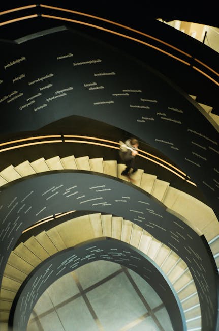 Scala a chiocciola con angoli geometrici e persona che scende, illustrando il concetto di prospettiva e profondità in architettura.