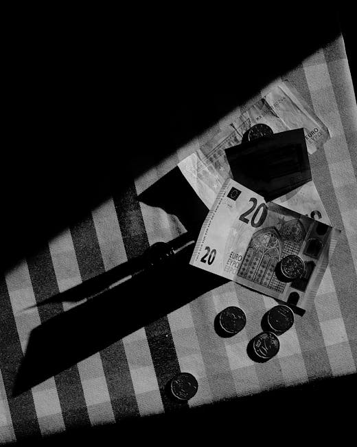 Banconote euro e monete su tessuto a scacchi, simbolo del sistema finanziario italiano e ruolo della Banca d'Italia.