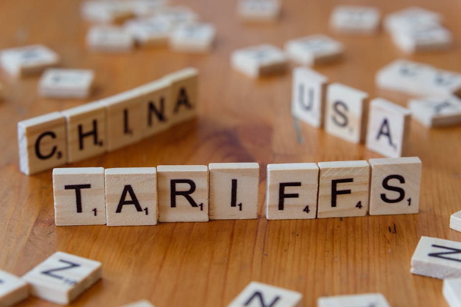 Dettaglio di tessere di Scrabble che compongono le parole 'China', 'USA' e 'Tariffs', simbolo delle tensioni commerciali e delle nuove regolamentazioni sull'AI.