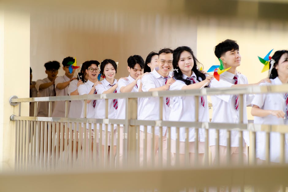 Studenti sorridenti con girandole colorate: metafora di un orientamento scolastico che accende lo sguardo e la curiosità verso il futuro.