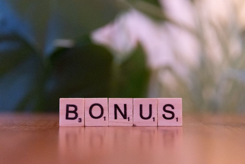 Lettere di legno formano la parola BONUS, simbolo del contributo di 1000 euro per i nuovi nati nel 2026.