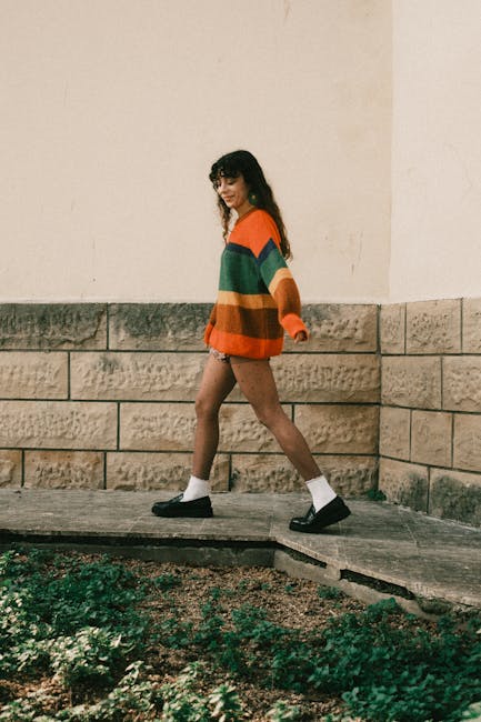 Ragazza che cammina con maglione a righe colorate e mocassini neri, contesto articolo su deepfake e minori coinvolti.