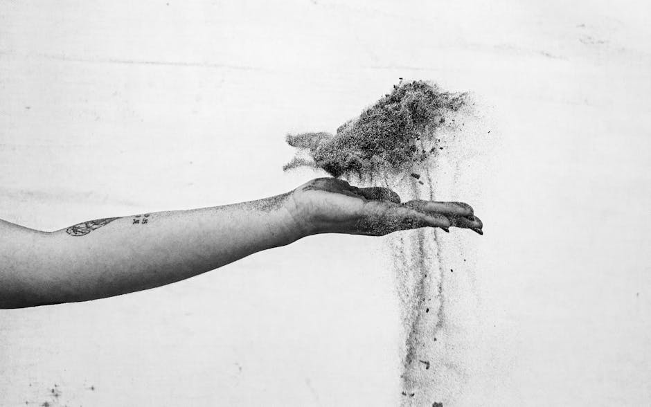 Mano che lascia cadere sabbia: metafora del tempo che scorre e della gestione delle attività uniche per massimizzare il tempo.