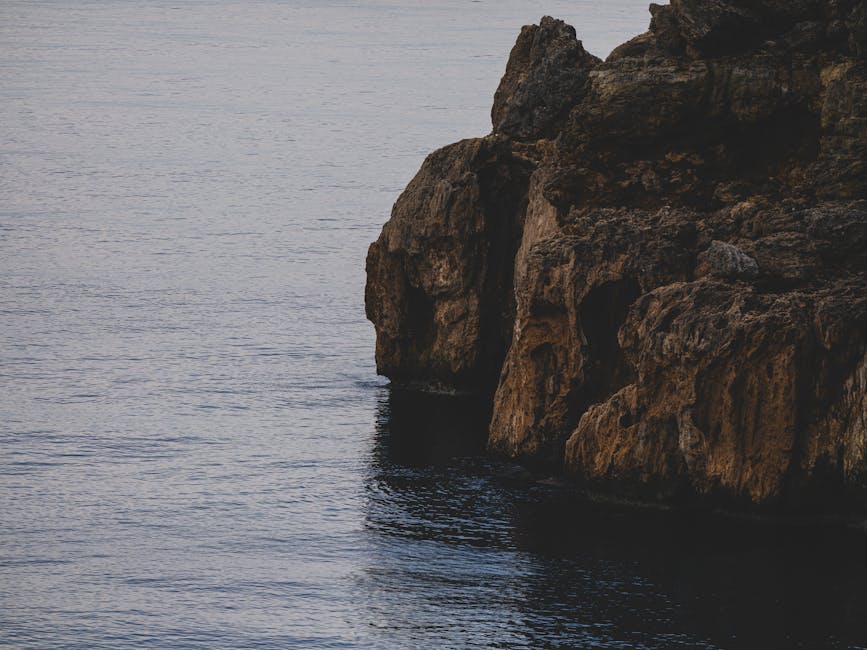 Scogliera a picco sul mare con angoli adiacenti visibili, esempio geometrico per l'articolo sugli angoli adiacenti.