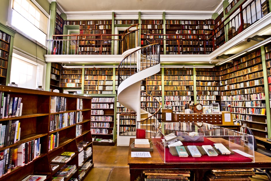 Biblioteca antica con scaffali pieni di libri e scala a chiocciola, richiamo all'eredità letteraria di Virgilio Marone.