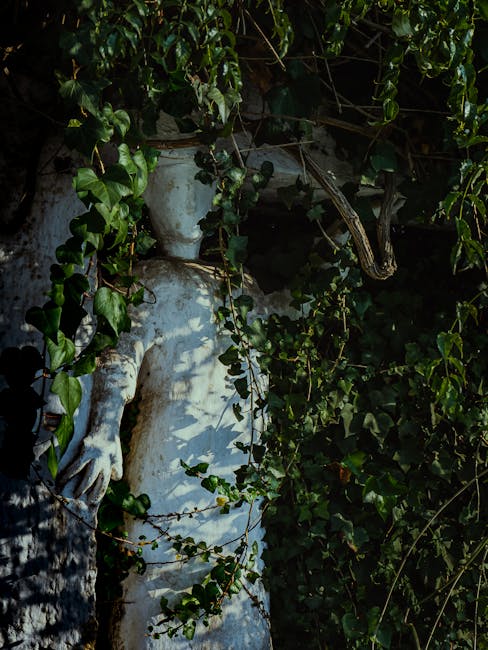 Statua antica in pietra bianca avvolta dall'edera, simbolo di conoscenza e mistero nel calcolo antico e nelle sue origini dimenticate.