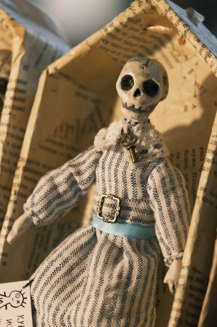 Allegoria della Morte: bambola scheletrica in abito a righe, chiave al collo, metafora del destino e dei temi nell'Eneide