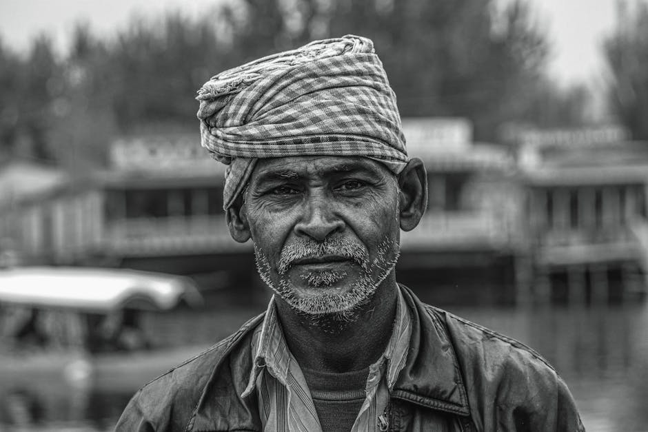 Ritratto in bianco e nero di un uomo anziano con turbante tradizionale, espressione intensa, possibile legame con cultura e patrimonio locale