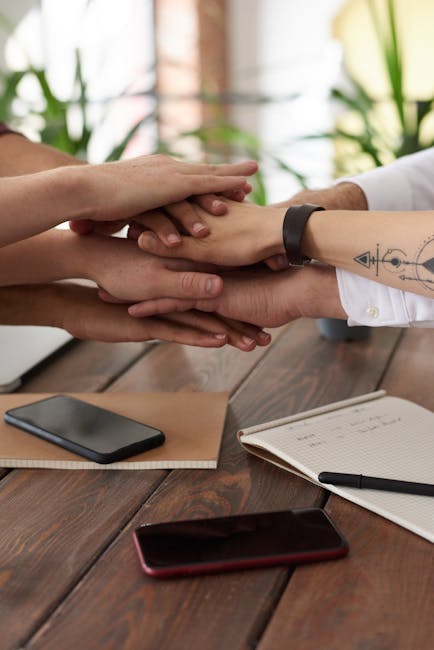Mani sovrapposte simbolo di collaborazione e preparazione agli esami orali, uniti per il successo e superare le sfide.