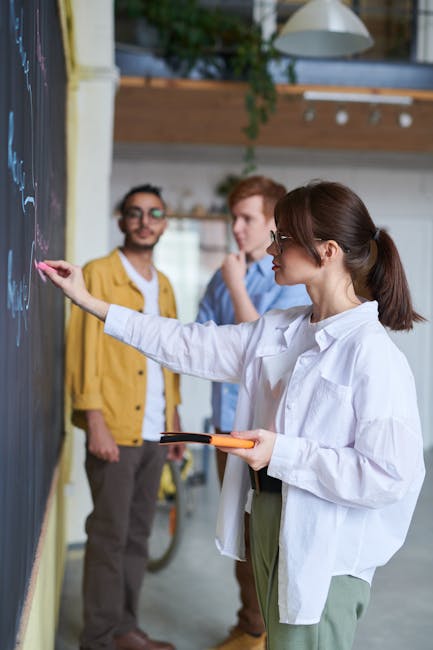 Docente spiega alla lavagna concetti chiave per la gestione scolastica e la relazione con il dirigente scolastico