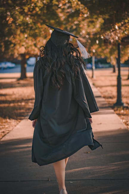 Studentessa laureata vista da dietro che cammina in un parco autunnale, simbolo di un futuro incerto dopo le proteste studentesche a Roma.