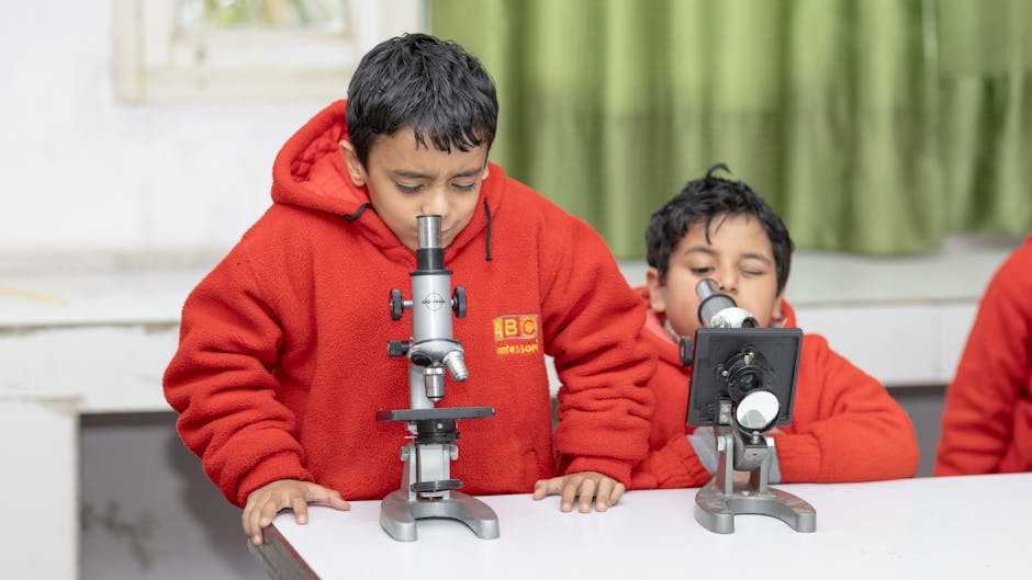 Ragazzi delle medie esplorano il mondo microscopico con i microscopi in laboratorio di robotica scolastica per un'avventura educativa