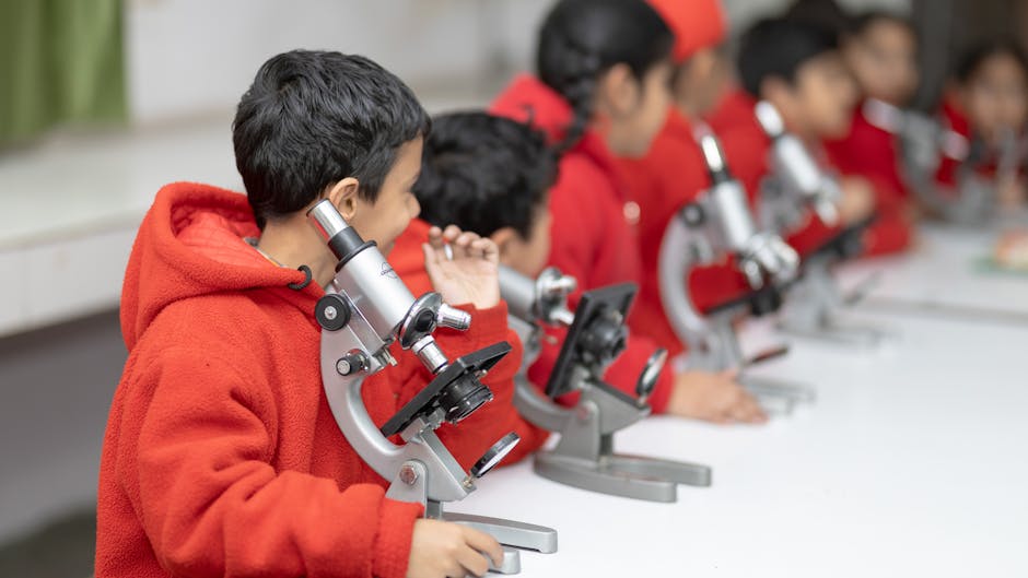 Bambini in laboratorio scientifico che utilizzano microscopi per un'esperienza didattica coinvolgente e memorabile a scuola.