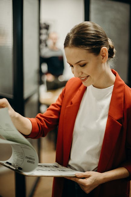 Donna sorridente esamina documenti di lavoro: soddisfazione professionale e felicità sul lavoro in Italia secondo la classifica.