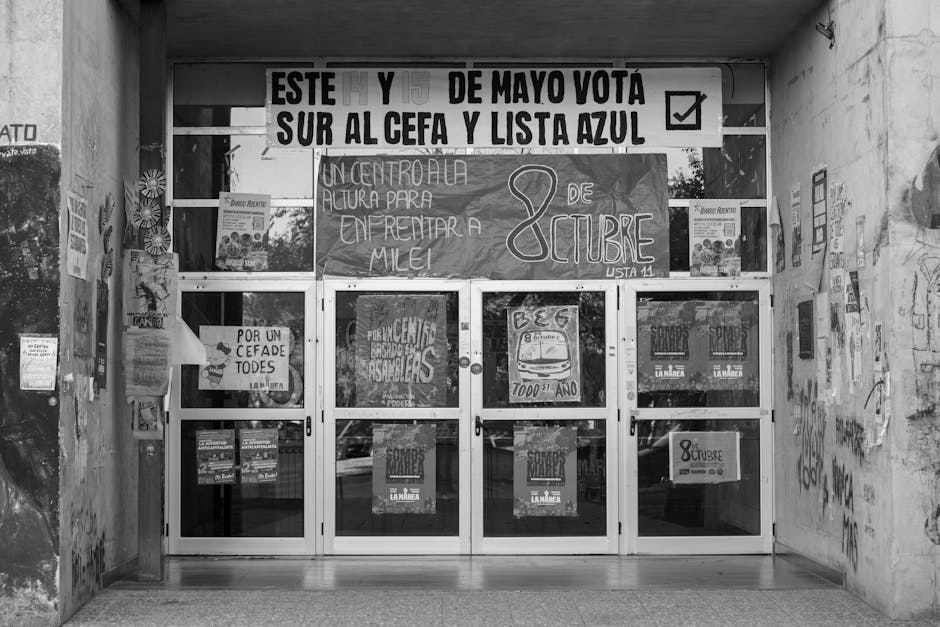 Facciata di università argentina tappezzata di manifesti e striscioni politici durante le proteste per i fondi all'istruzione pubblica.