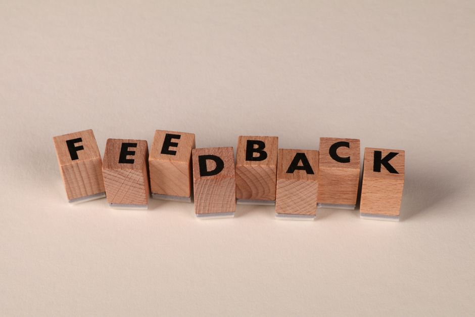 Lettere di legno che compongono la parola FEEDBACK, simbolo di comunicazione e risposte.