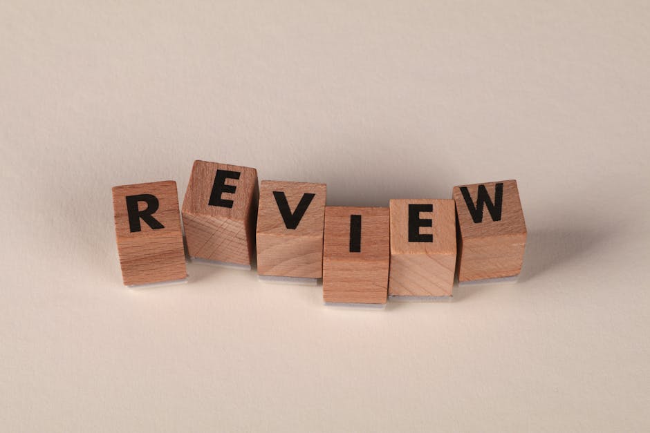 Blocchi di legno con la parola REVIEW, concetto di valutazione e feedback nell'insegnamento unico e pratiche didattiche efficaci.
