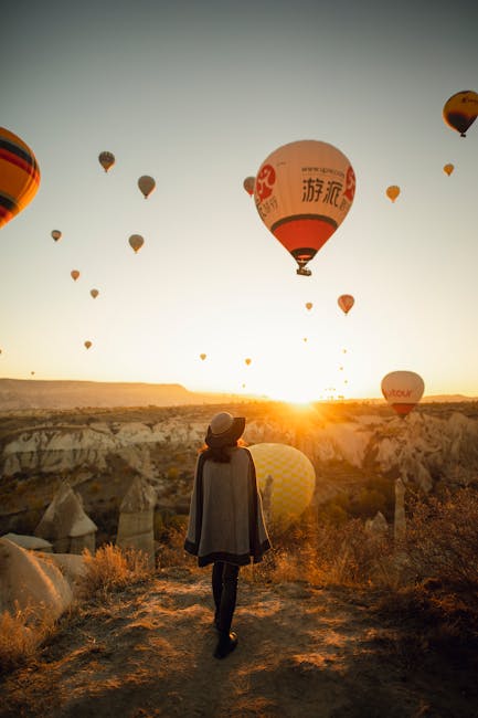 Donna ammira mongolfiere in Cappadocia al tramonto, simbolo di un percorso unico come l'Accademia dei Finanzieri.