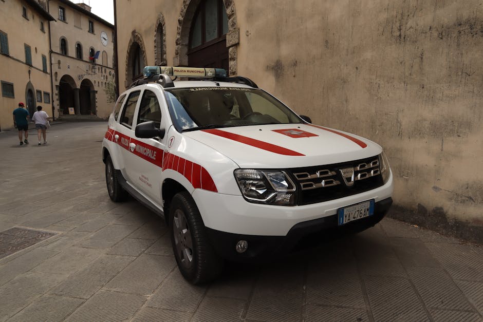 Auto della Polizia Municipale in un borgo toscano, simbolo di sicurezza e legalità per una cultura della pace promossa da Dacia Maraini.