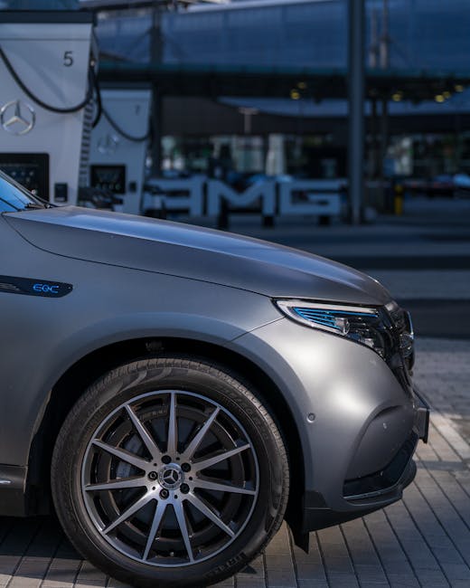 Auto elettrica Mercedes EQC grigia a una stazione di ricarica, esempio di mobilità sostenibile in una smart city.