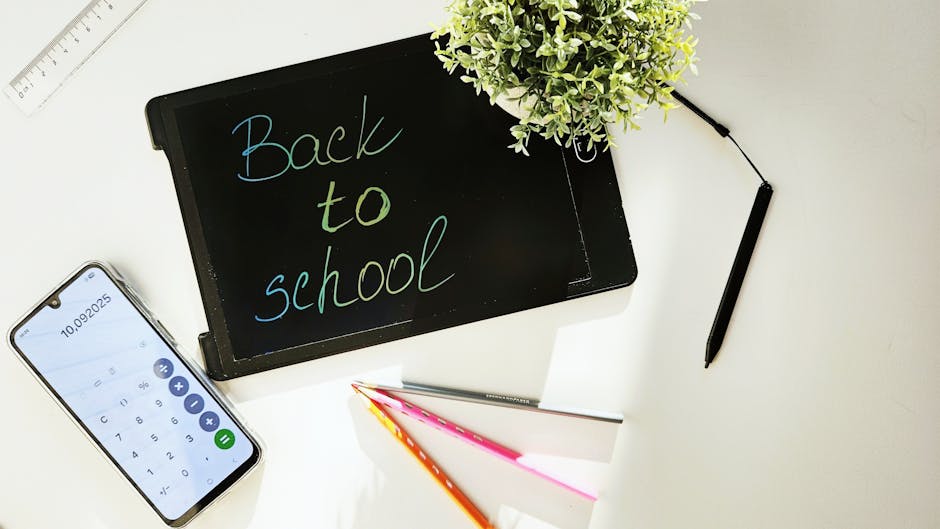 Materiale scolastico su scrivania: lavagna con Back to School, calcolatrice, penne. Concetto di psicologia dell'apprendimento e successo scolastico.