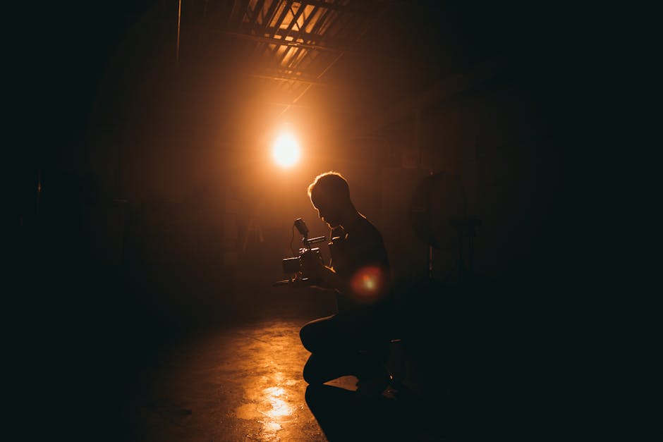 Studente di indirizzo tecnico cinematografico al lavoro con attrezzatura professionale in ambiente illuminato, preparazione al futuro.