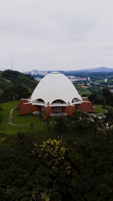 Edificio a forma di cupola bianca circondato dal verde, esempio di architettura sostenibile e design educativo per la cultura ambientale.