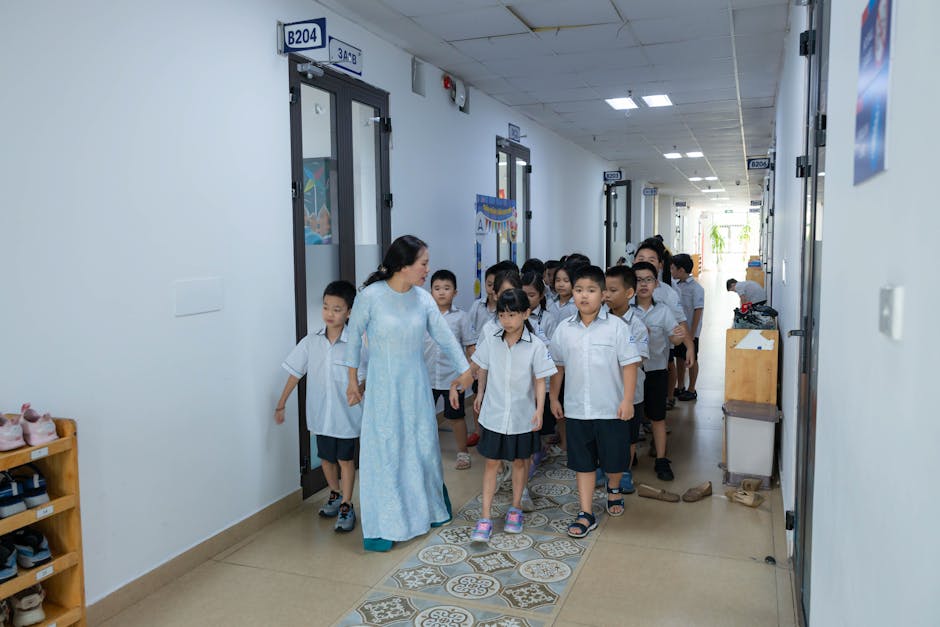 Docente accompagna studenti in corridoio scolastico. Riforma Valditara per alloggi e servizi, contrasto al caro affitti per insegnanti fuori sede.