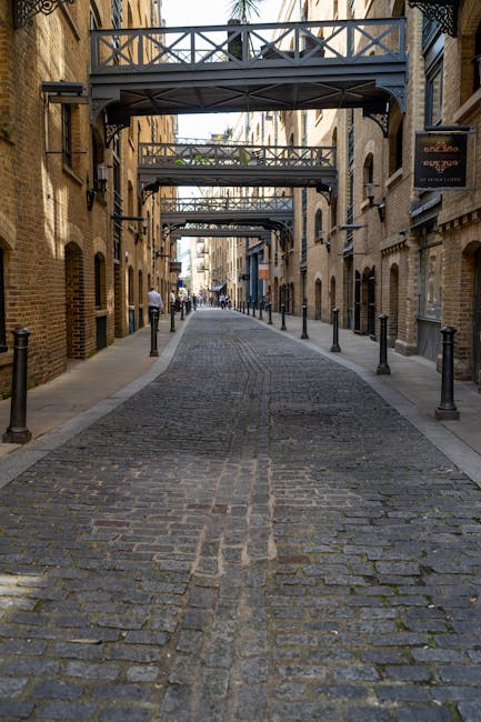Strada acciottolata con ponti pedonali a Londra: un percorso circolare tra storia e architettura urbana. Esplora la geometria della città.