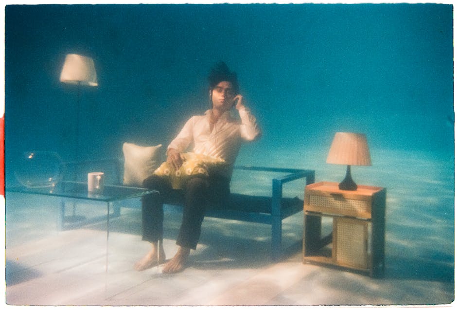 Uomo seduto sott'acqua in un salotto surreale, metafora di Unimi Matematica e la sua capacità di immergere gli studenti in un mondo nuovo.