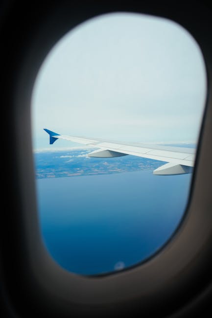 Vista aerea di mare e costa dall'oblò di un aereo, metafora del viaggio e della scoperta nel mondo della matematica a Bicocca.