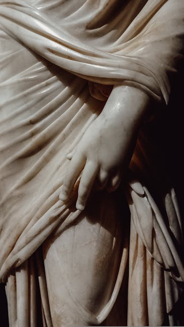 Dettaglio scultura in marmo mano e drappeggio ispirata all'Eneide, simbolo della classicità e della sua influenza duratura.