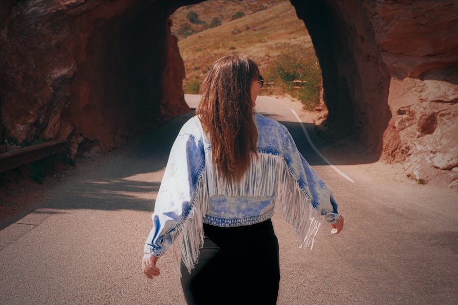 Donna con giacca a frange in un tunnel roccioso, metafora della scoperta genetica e del viaggio nella Seconda Legge di Mendel