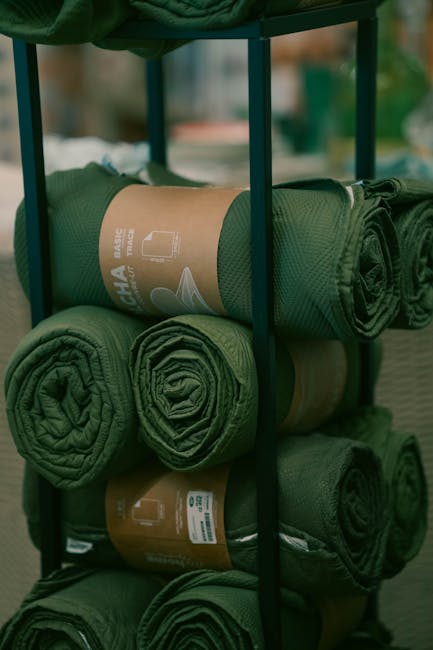 Rotoli di tessuto verde su scaffale, visualizzazione pratica di diritto commerciale e applicazioni essenziali per studenti e professionisti.