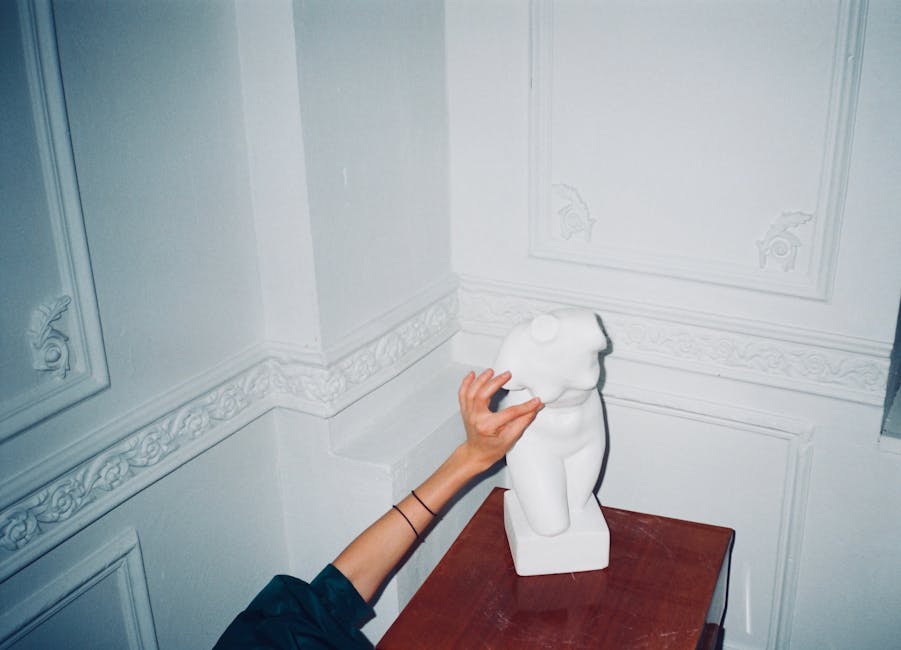 Scultura classica bianca toccata da una mano, evocazione dell'arte e della forma unica di Virgilio nella letteratura antica.