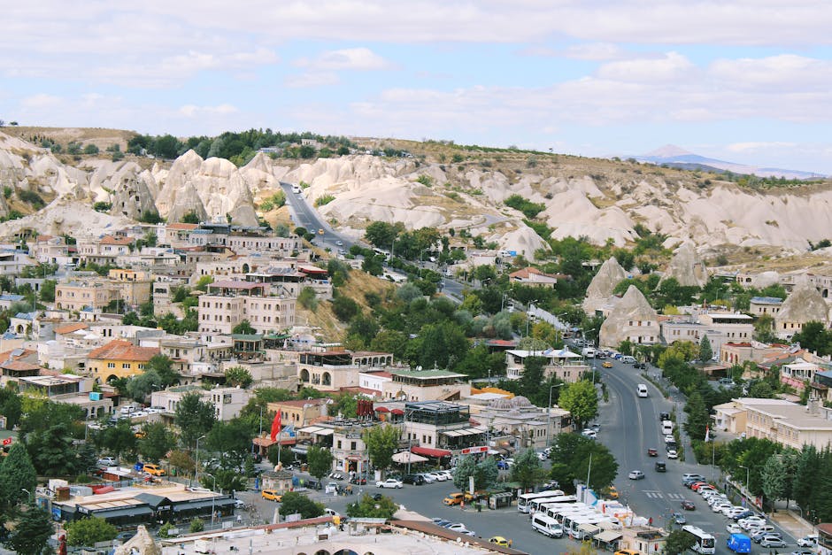 Paesaggio urbano di Goreme in Cappadocia con formazioni rocciose uniche e traffico stradale, ideale per studenti che viaggiano a Roma.