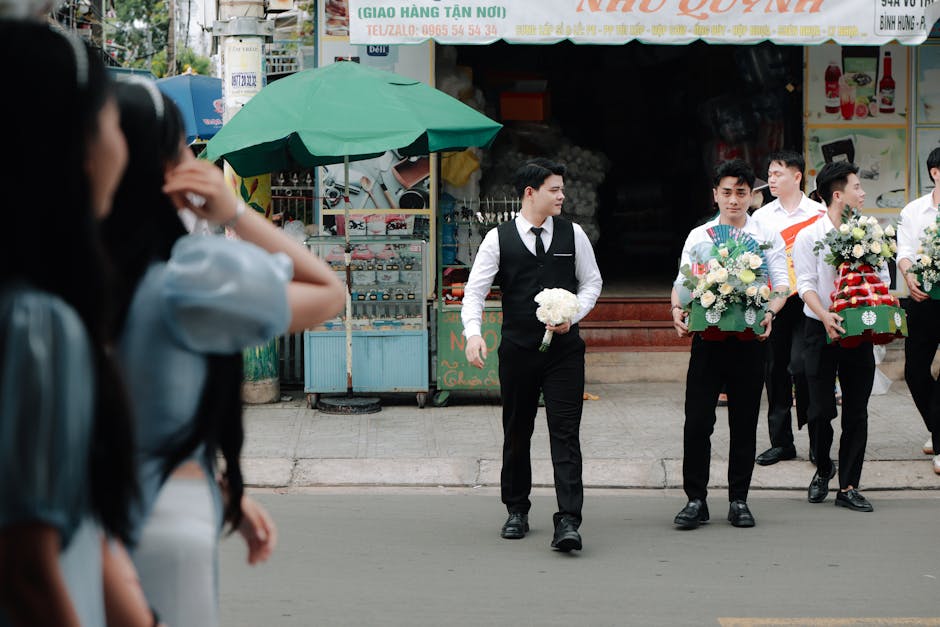 Rituale nuziale moderno: uomini in abiti formali portano offerte floreali, legami culturali e innovazioni nella celebrazione.