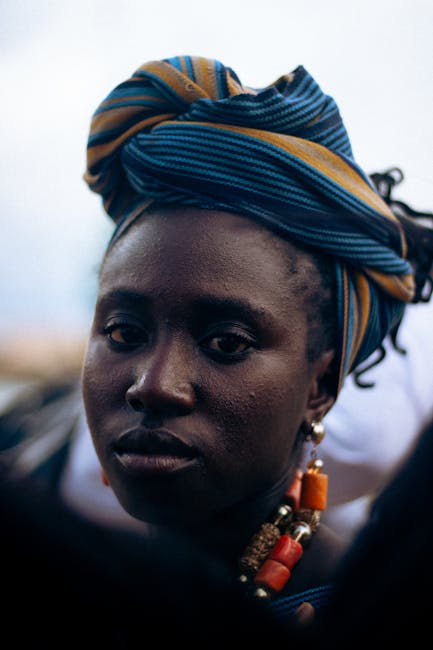 Ritratto di donna africana con turbante e gioielli che esprime dignità e umanità oltre le valutazioni numeriche