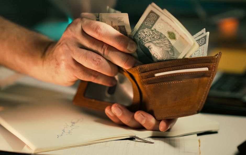 Aumento stipendi posizioni economiche ATA: mano con portafoglio pieno di banconote da 100 złoty, simbolo di retribuzione e guadagno.