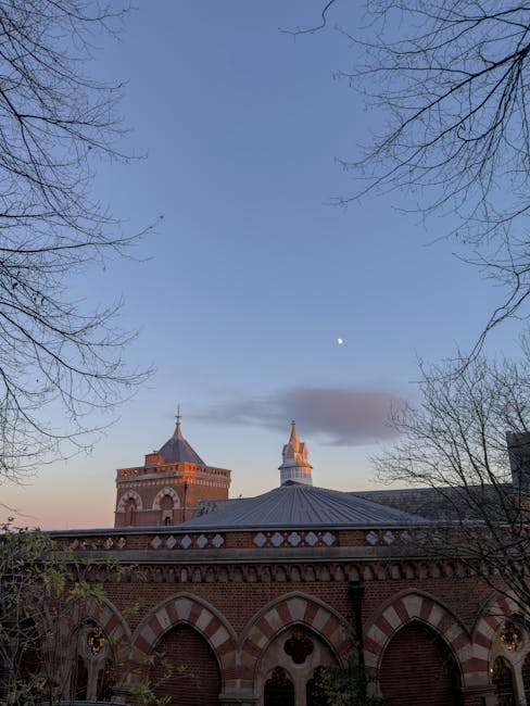 Edificio scolastico storico a Roma con architettura in mattoni rossi e cielo sereno, simbolo delle sfide gestionali delle palestre scolastiche.