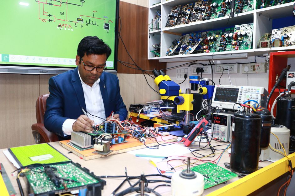 Insegnante di istituto tecnico lavora su circuiti elettronici, simulando l'ambiente di apprendimento e le sfide della riforma scolastica.