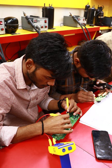 Studenti tecnici al lavoro su circuiti elettronici, formazione professionale per l'industria italiana, carenza di competenze tecniche.