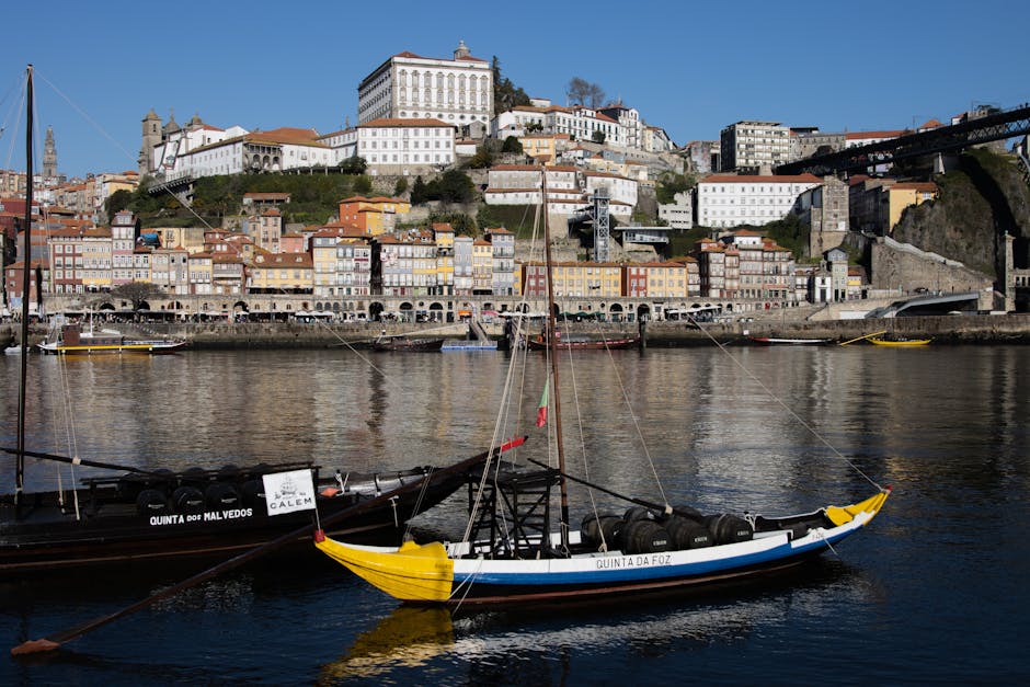 Paesaggio urbano di Porto con barche Rabelo sul fiume Douro, simbolo di stabilità finanziaria come gli arretrati del personale ATA entro il 2026