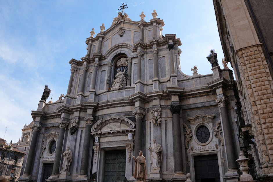Facciata del Duomo di Catania, architettura barocca e statue, simbolo della città al centro del dibattito sull'intitolazione a Sant'Agata.